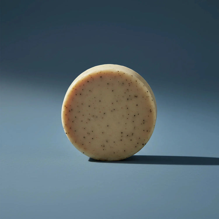 Beach Rain | Grass Fed Tallow | Shampoo Bar Blind Pirate Trading Co. a gorgeous, round and tan shampoo puc stands on it's side.