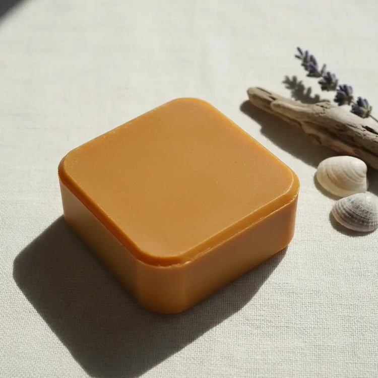 Sovereign Gold square Passage travel size soap bar with rounded corners on linen, styled with dried lavender, and seashells — Blind Pirate Trading Co.