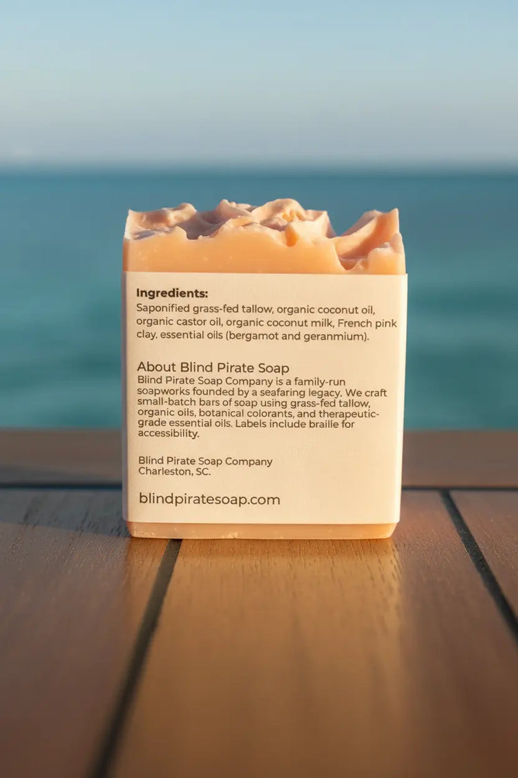 Coconut Rose tallow soap bar perched on a sailboat deck, sparkling sun-kissed water stretching endlessly beyond the gleaming rail.