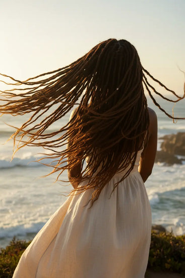 Locs Female standing on the cliff, healthy hair flowing in the wind.