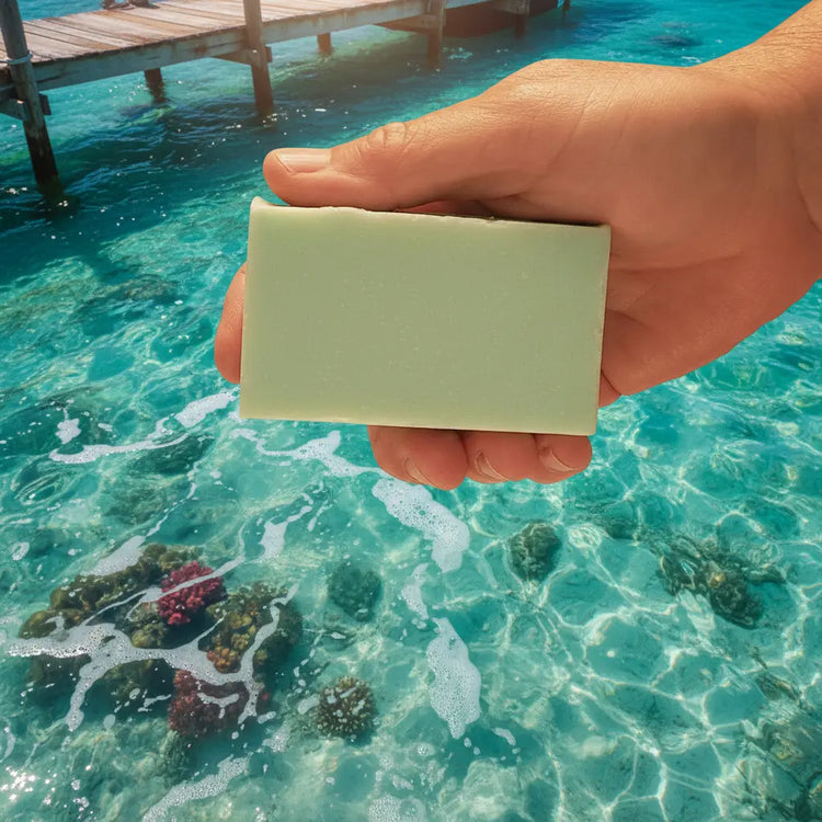 Spearmint Reef Ballast cut bar by Blind Pirate Trading Co. — bar held in hand against a crystal turquoise ocean reef