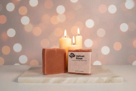 White Onyx + Three Tapers — Two Velvet Rose bars side by side — one wrapped, one not, glowing warmly against a soft twinkling lights.